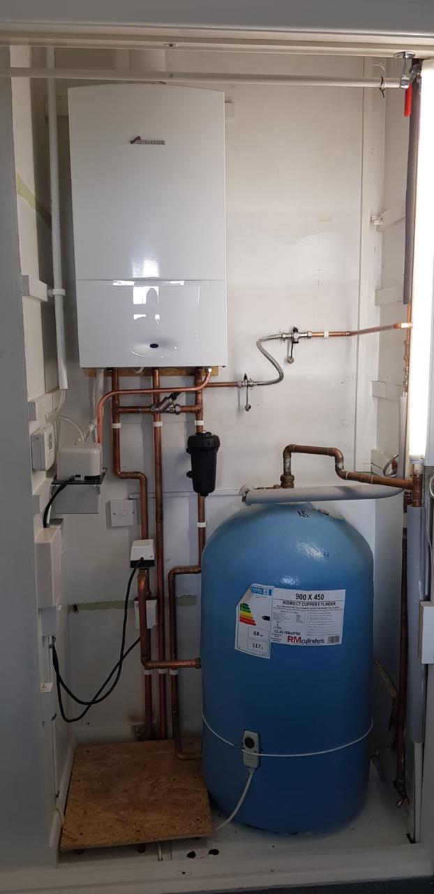 Worcester Bosch system boiler above a copper hot water cylinder in an outdoor cupboard